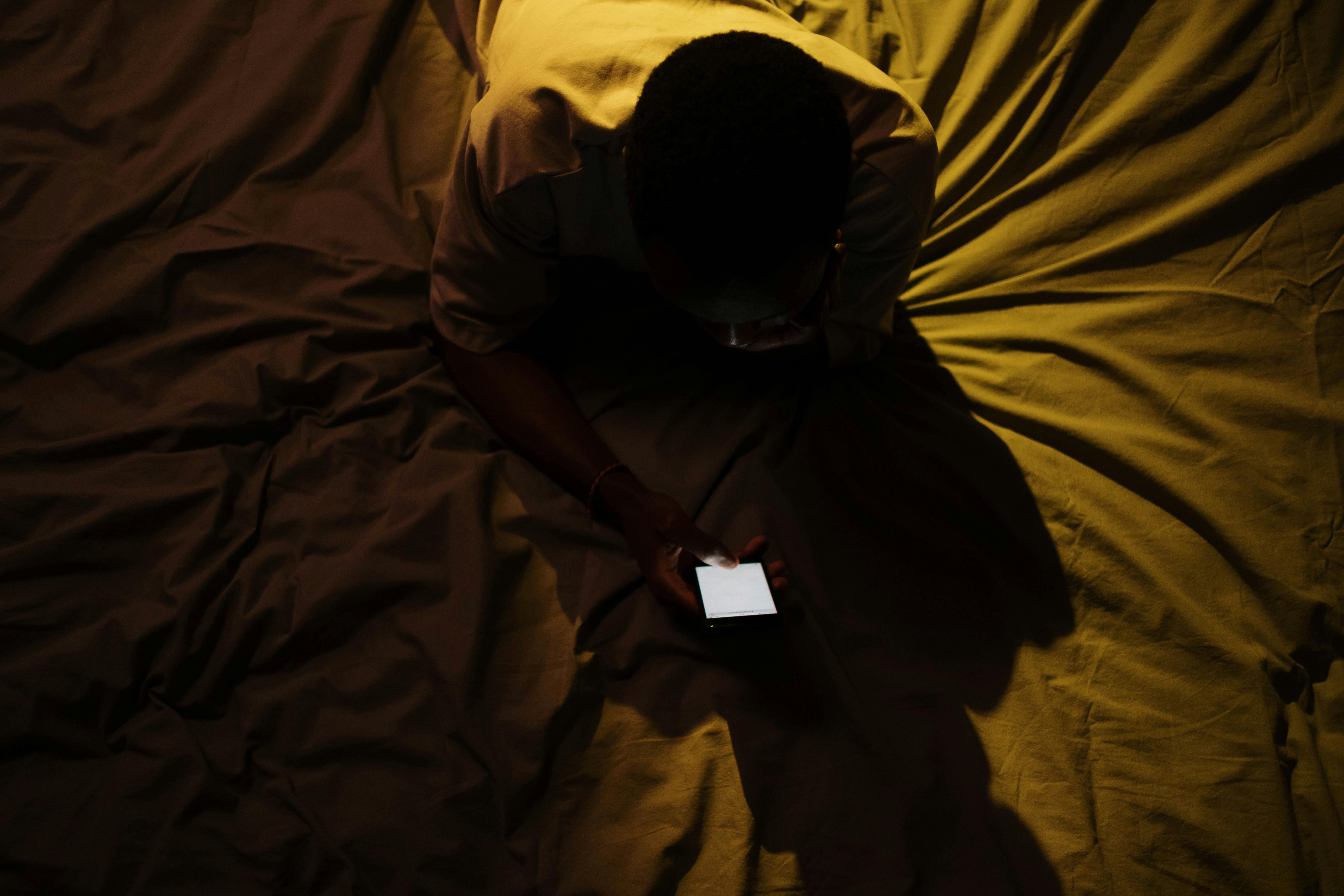 Credit: Pexels / Cotton Bro. Jongen op bed met zijn smartphone. 