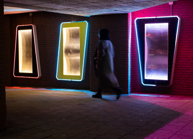man loopt door creatief verlichte tunnel 