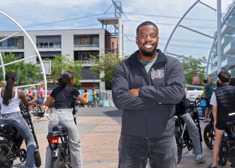 Jongerenwerker Shaquille Krak poseert tussen jongeren